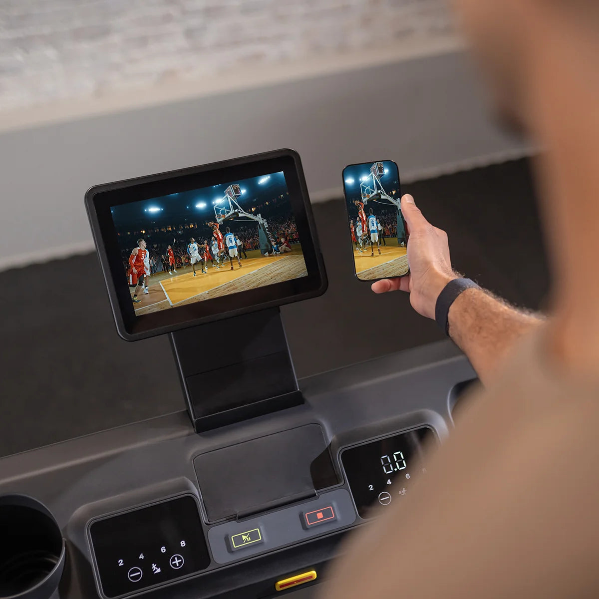Écran du tapis Inspire et téléphone affichant un entraînement de basketball
